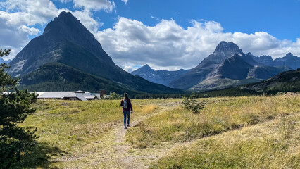 Naklejka premium Woman Hiking around Swiftcurrent Lake in Many Glacier Region of Glacier National Park