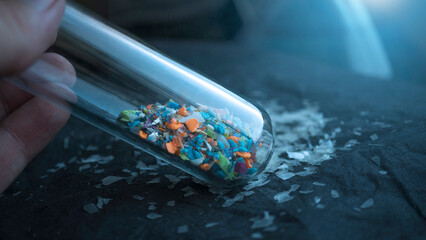 Microplastics inside a glass lab test tube. Concept of plastic pollution and industrial waste...
