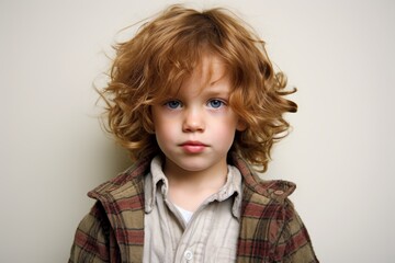 Portrait of a cute young boy with blond curly hair and blue eyes