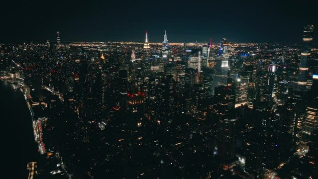 Drone flight above high skyscrapers building after dark.Scenic night time areal above modern night city. Illuminated Manhattan USA. New York City views background. Aerial Time Square downtown panorama