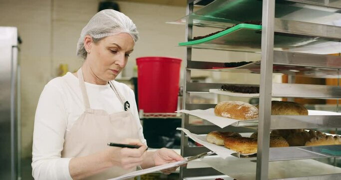 Woman, inventory and inspection checklist in bakery with paperwork, small business or clipboard. Quality control, writing or mature chef with food, bread or notes for cooking in restaurant kitchen