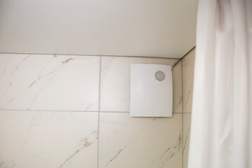 fan in the shower closed with a beautiful decorative cover, diffuser and curtain in the bath