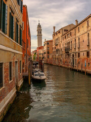 The leaning bell tower of the Church of San Giorgio dei Greci and water canqal with boats in Venice, Italy.
