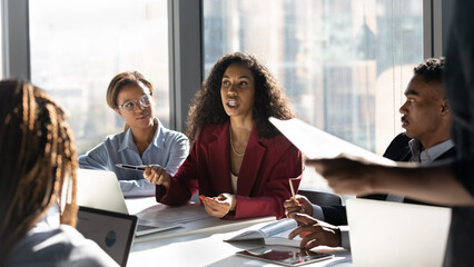 Presenting idea. Inspired black african woman employee propose marketing plan to interested diverse...