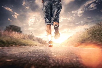 Poster männlicher läufer joggt auf einer straße aufwärts mit strahlender sonne in der natur © thebigticket20