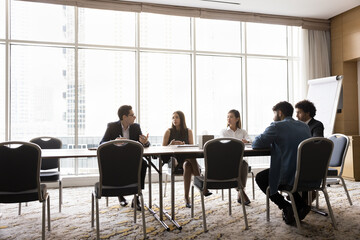 Diverse professional team of young business colleagues brainstorming on work project in boardroom....