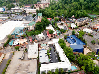 Fototapeta premium city of Gatlinburg in Tennessee and the Great Smoky Mountains from a bird's eye view, a tourist mecca with hotels, parking and shops.