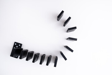 Black domino on a yellow background. Domino effect concept. Business, risk, management and finance concept