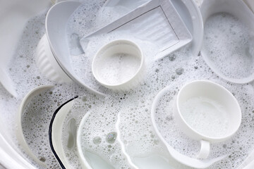 Dish washing, Dirty dishes soaking in kitchen sink.