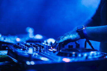 Close up of hands with mixing console making electro music on a festival.
