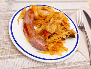 Roasted sausages served with side dish of cabbage stewed