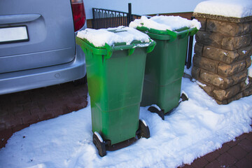 green trash containers in the parking lot near the house, European house