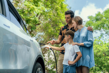 Family road trip vacation with electric vehicle, lovely family recharge EV car with green and clean...