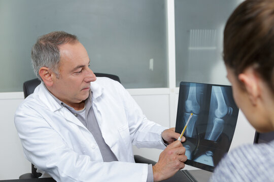 doctor showing x-ray image to senior female patient