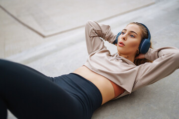Fototapeta premium Happy woman in sports outfit doing exercises outdoors in the morning. Sport woman doing stretching exercise. Sport, Active life, sports training, healthy lifestyle.