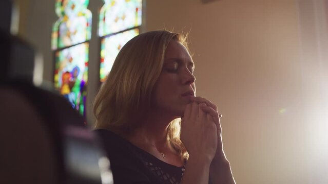 Blond woman praying inside the church