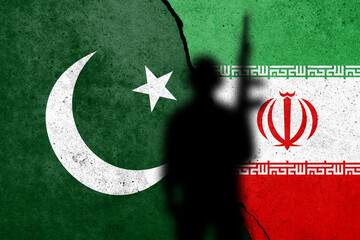 Flags of Pakistan and Iran painted on the concrete wall with soldier shadow.