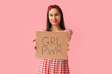 Portrait of young pin-up woman holding sign with text GRL PWR on pink background. Women's History...