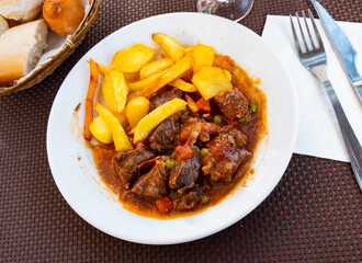 Delicious beef stew served on plate with potatoes and stewed vegetables