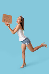 Portrait of young pin-up woman holding sign GRL PWR on blue background. Women's History Month