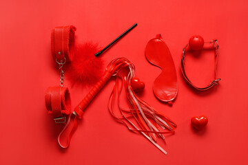 Composition with different sex toys and hearts on red background. Valentine's Day celebration