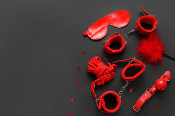 Composition with different sex toys and sequins on dark background. Valentine's Day celebration