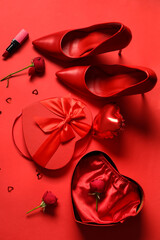 Fototapeta na wymiar Beautiful gift box with sexy lingerie, shoes and rose flowers on red background. Valentine's Day celebration