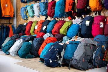On wall and floor there is showcase with backpack for travelers and tourists - for climbing and hiking, waterproof clothes
