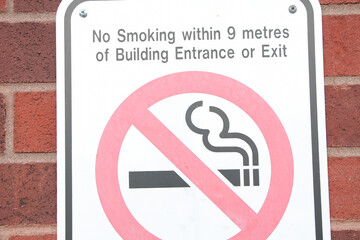 no smoking within 9 metres of building entrance or exit writing caption text rectangle horizontal...