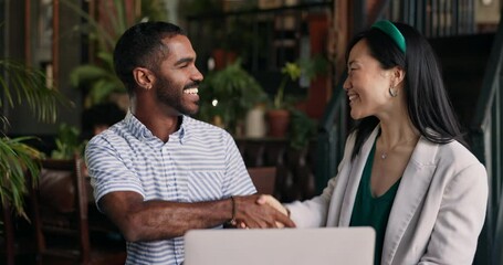 Happy business people, laptop and handshake at cafe for meeting, partnership or deal together. Man and woman shaking hands by computer in thank you, agreement or teamwork at coffee shop or restaurant