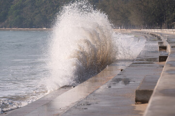 Huge waves are hitting seawall.