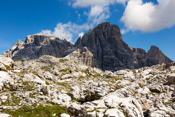 Fototapeta na wymiar Bright rocks and mountain peaks are illuminated by bright daytime summer sun in Dolomites.