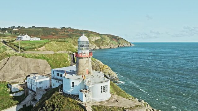 orbits around a lighthouse on top of a cliff, Irish landscape, aerial view