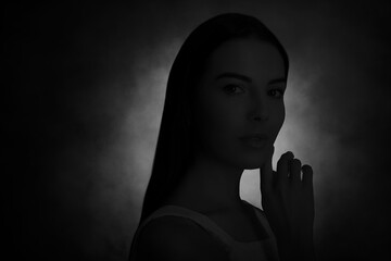 Silhouette of woman in darkness. Portrait on black background