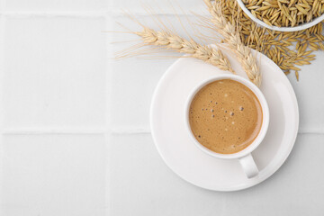 Cup of barley coffee, grains and spikes on white table, flat lay. Space for text