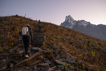 Group of tourist while hiking on steep stairs to Mardi Himal base camp with beautiful view of Mt.Machapuchare in the background.