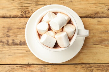 Tasty hot chocolate with marshmallows on wooden table, top view