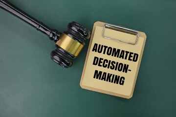 judge's gavel and paper board with the words automated decision-making. the concept of automatic decision making