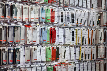 The Hague, Netherlands - January 03 2022: phone covers are hanging on the wall in a telecommunications store selling all sorts of items for a smartphone including repair