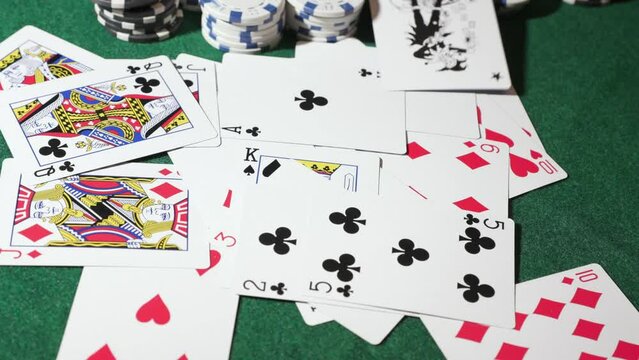Pokers chips and playing cards on green table background
