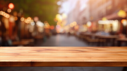 Naklejka na ściany i meble Warm wooden tabletop with a vibrant blurred street scene in the background at dusk.