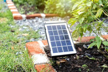 A small solar panel install placed on the ground in the garden under for reserve electricity for...