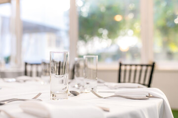 Wedding reception restaurant interiors, tables, plates, glasses, cutlery