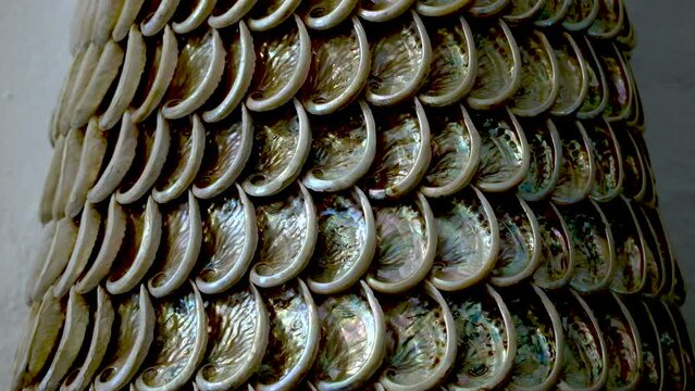 Push-in slider shot toward South African abalone shells glued together in a pattern to make a tower