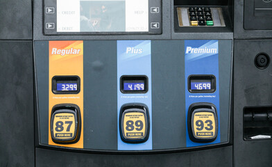 gas pump nozzle with rising numbers on the display, symbolizing inflation and escalating gas prices