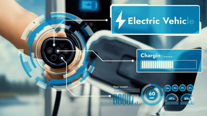 Focus hand pointing EV charger in front of camera display smart battery status hologram in blurry...