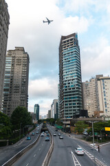 Fototapeta na wymiar Urban landscape of the city of São Paulo with plane over the buildings, Brazil. Avenida Cidade Jardim.