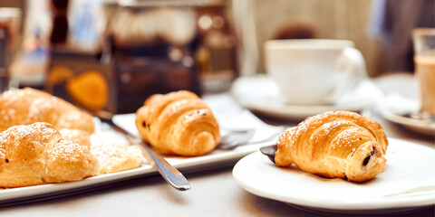 Coffee and Croissants on a White Table in a Cozy Cafe with Hot Espresso and Sweet Pastries
