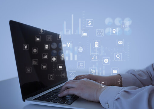 デスクでPC操作するビジネスパーソンとアイコン - Powered by Adobe