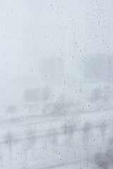 Glass window with raindrops, rainy weather day outside, abstract photo of cloudy mood